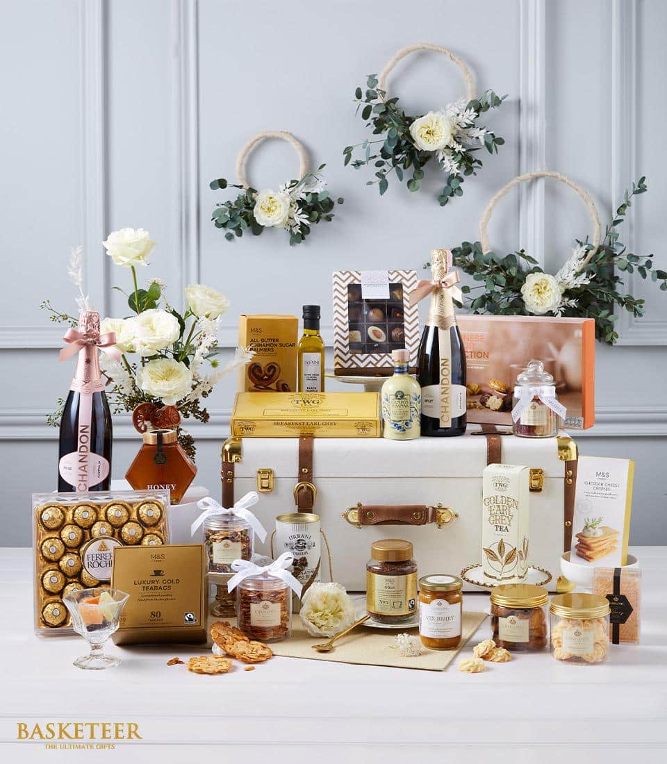 Luxury white hamper with gold accents featuring sparkling wine, gourmet chocolates, and artisan treats
