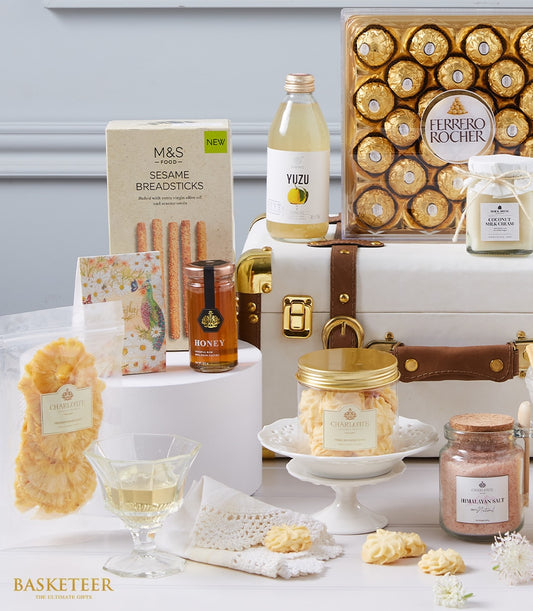 Luxe white leather trunk hamper with gourmet chocolates, yuzu drink, honey, cookies, and premium treats