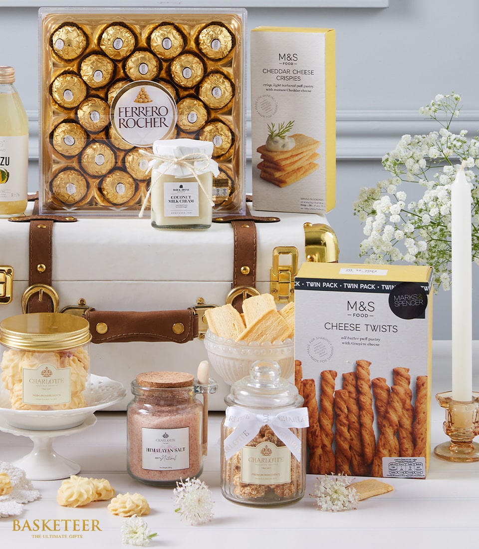 Deluxe gourmet hamper with chocolates, cheese crisps, cookies, and artisan spreads in white leather trunk