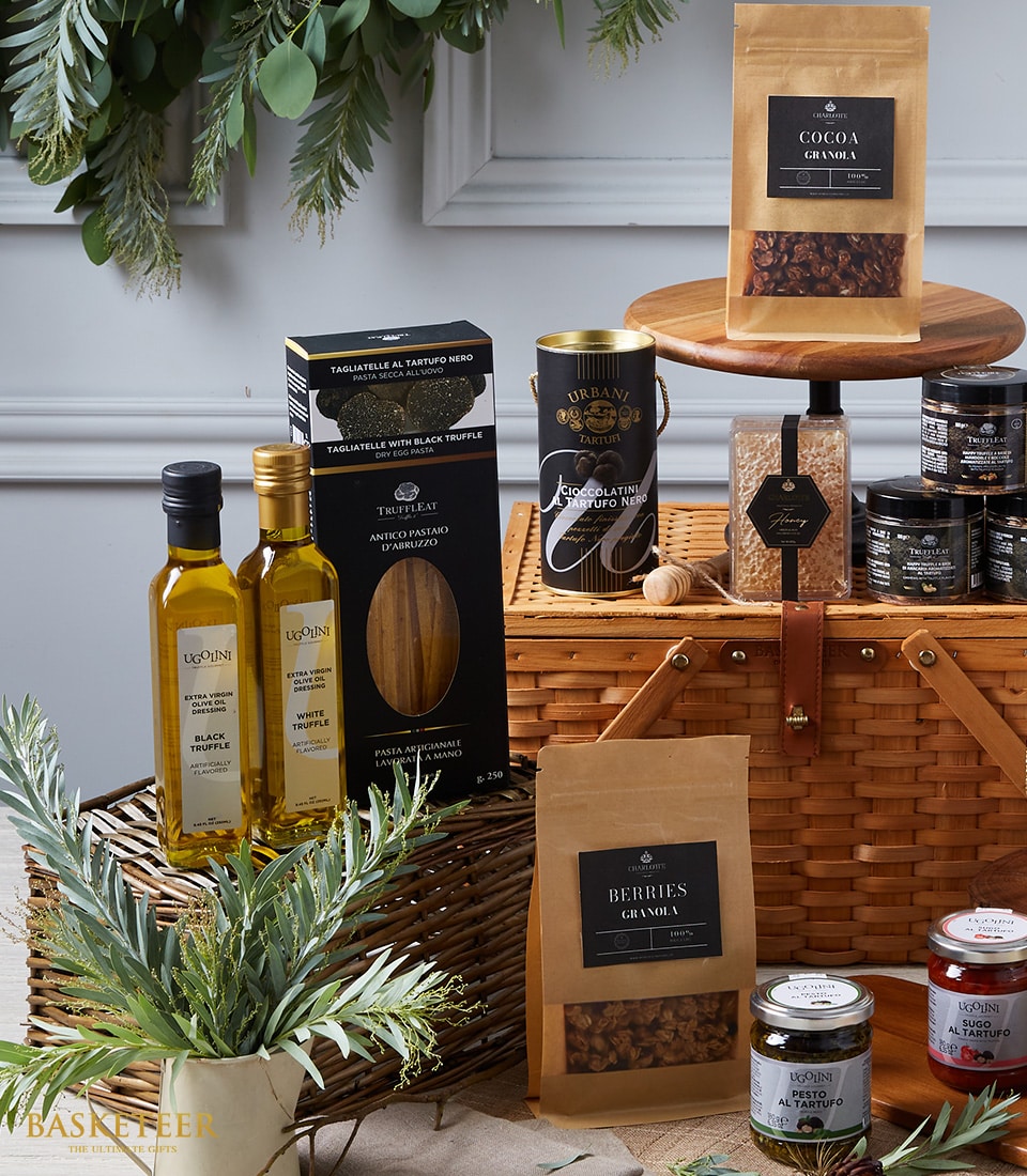 Luxury truffle gourmet hamper with black truffle oils, pasta, chocolate, granola, and artisan condiments in wicker basket