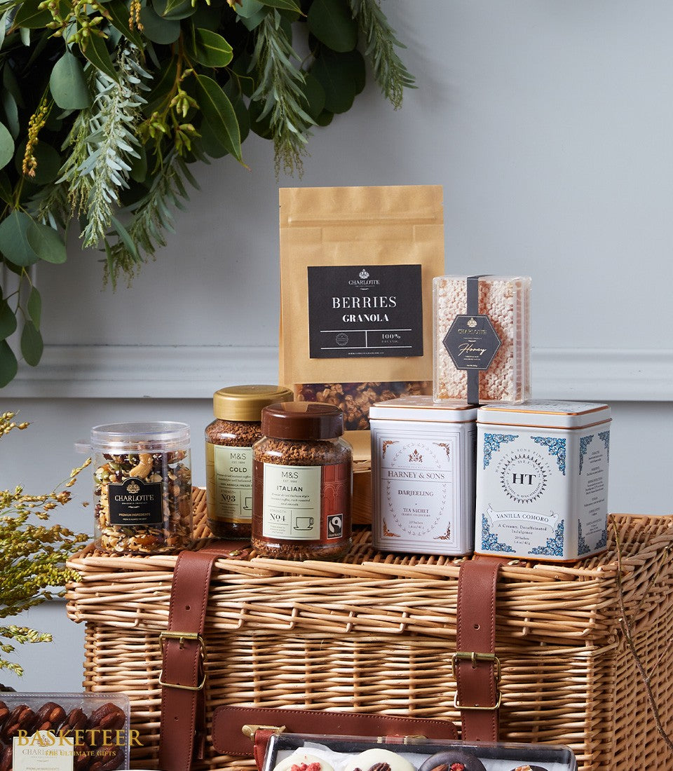 Luxury gourmet hamper with granola, coffee, tea, nuts and chocolates in wicker basket