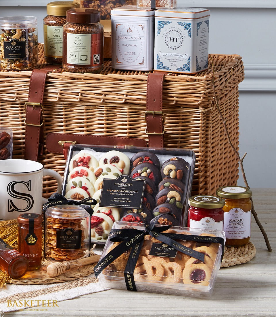Luxury wicker picnic hamper filled with gourmet coffee, tea, chocolates, cookies, honey, preserves and ceramic mug