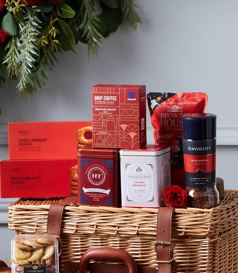 Luxury woven wicker hamper with imported gourmet foods, specialty coffee, tea, and treats in red and white packaging