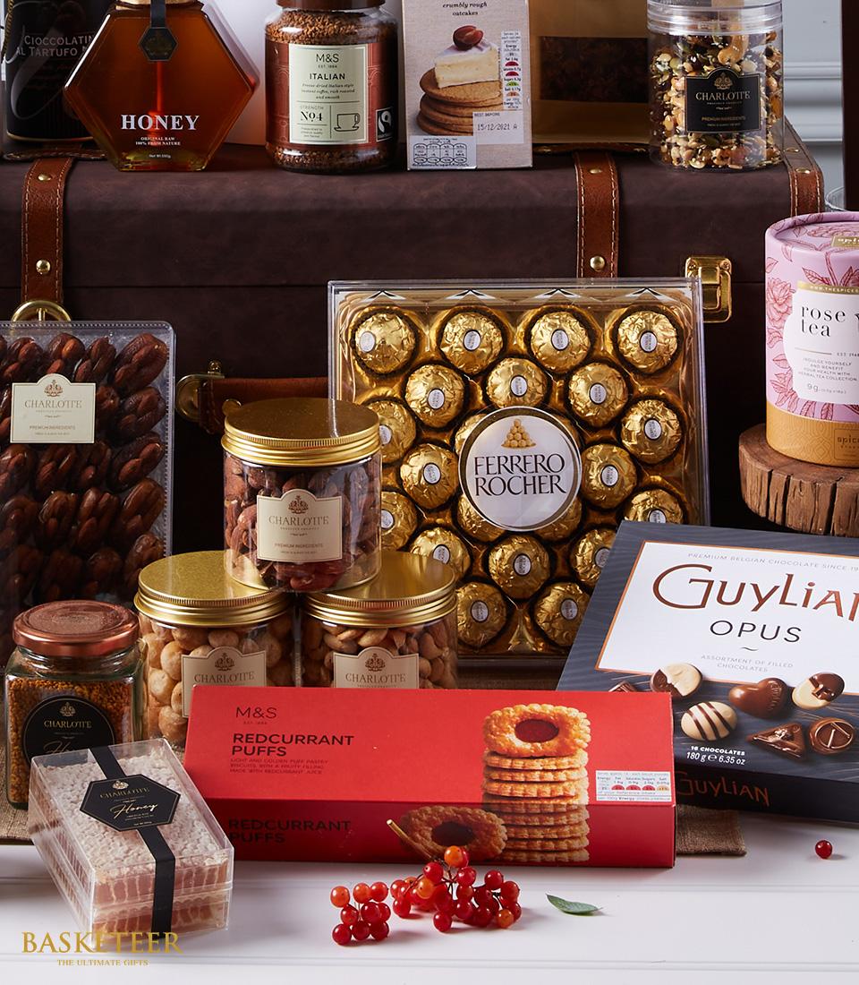Luxury gourmet hamper with Ferrero Rocher chocolates, premium nuts, honey, coffee, and artisan snacks in elegant