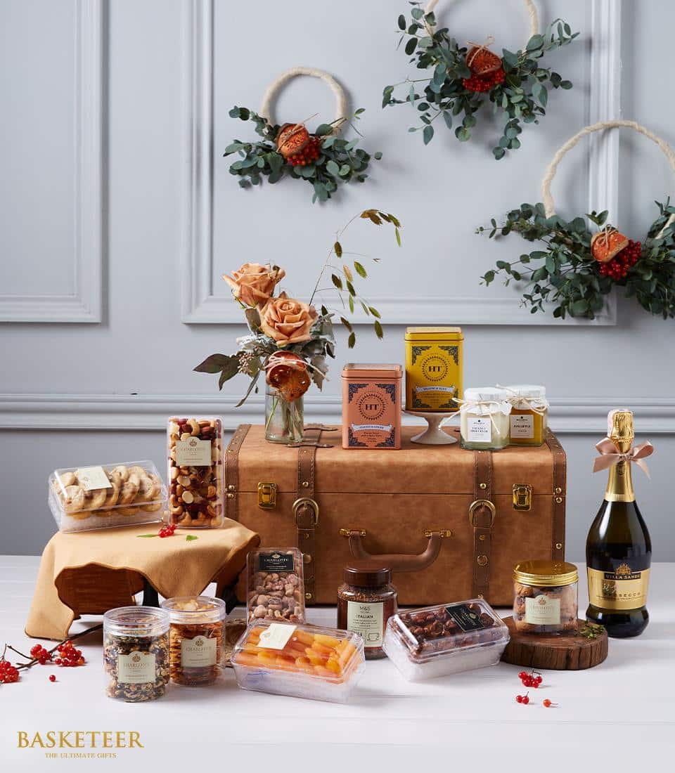Luxury wine hamper with sparkling wine, peach roses, gourmet treats, and artisan gift box