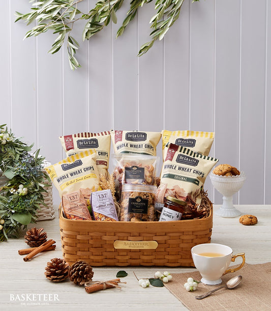 Woven gift basket filled with whole wheat chips, plant-based milk, nuts, and raw honey for New Year wellness gifting
