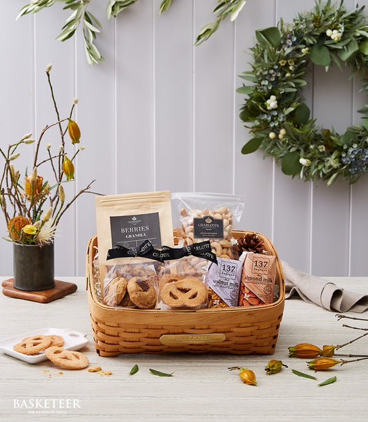 Woven gift basket filled with gourmet granola, cashews, cookies, and plant-based milk for New Year gifting