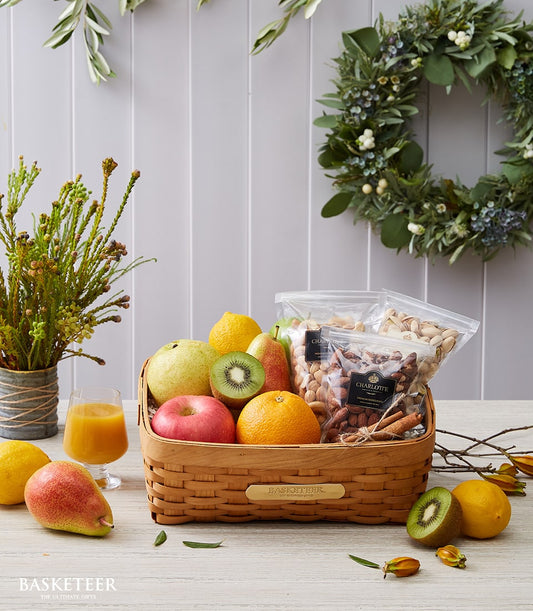 Premium fruit and nut gift basket with fresh apples, pears, citrus, almonds and pistachios for wellness