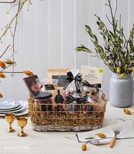 Basketeer premium hamper delivery Thailand. A gold wire basket filled with gourmet granola, nuts, and sesame breadsticks. Perfect corporate gift Bangkok.