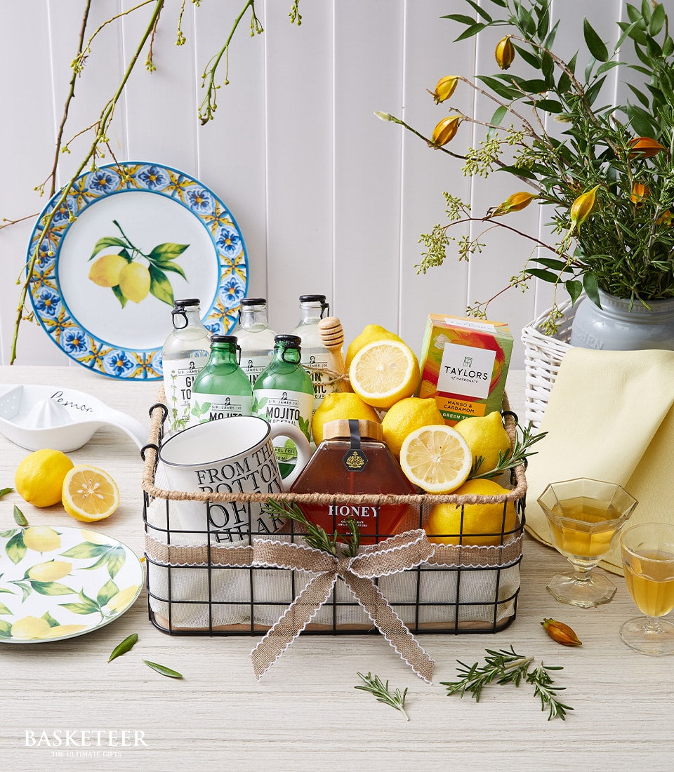 Zesty lemon gift basket with honey, tea, gin, tonic, mojito bottles, mug and fresh rosemary