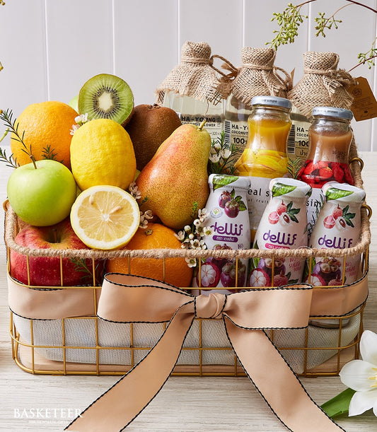 Premium fruit and wellness gift basket with fresh citrus, apples, kiwi, artisan juices and botanical florals in gold wire