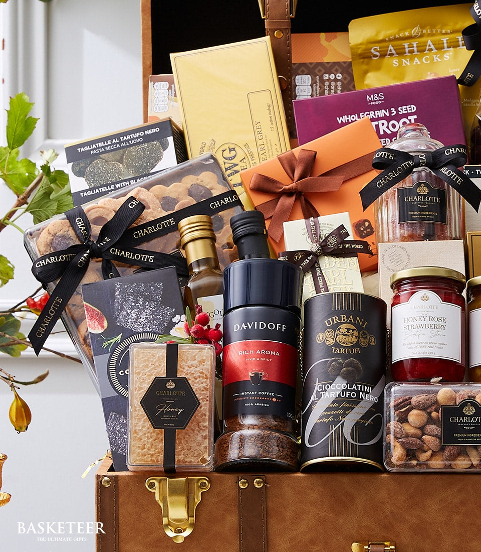 Luxury exotic gourmet hamper with truffles, pasta, honey, and coffee in brown leather trunk