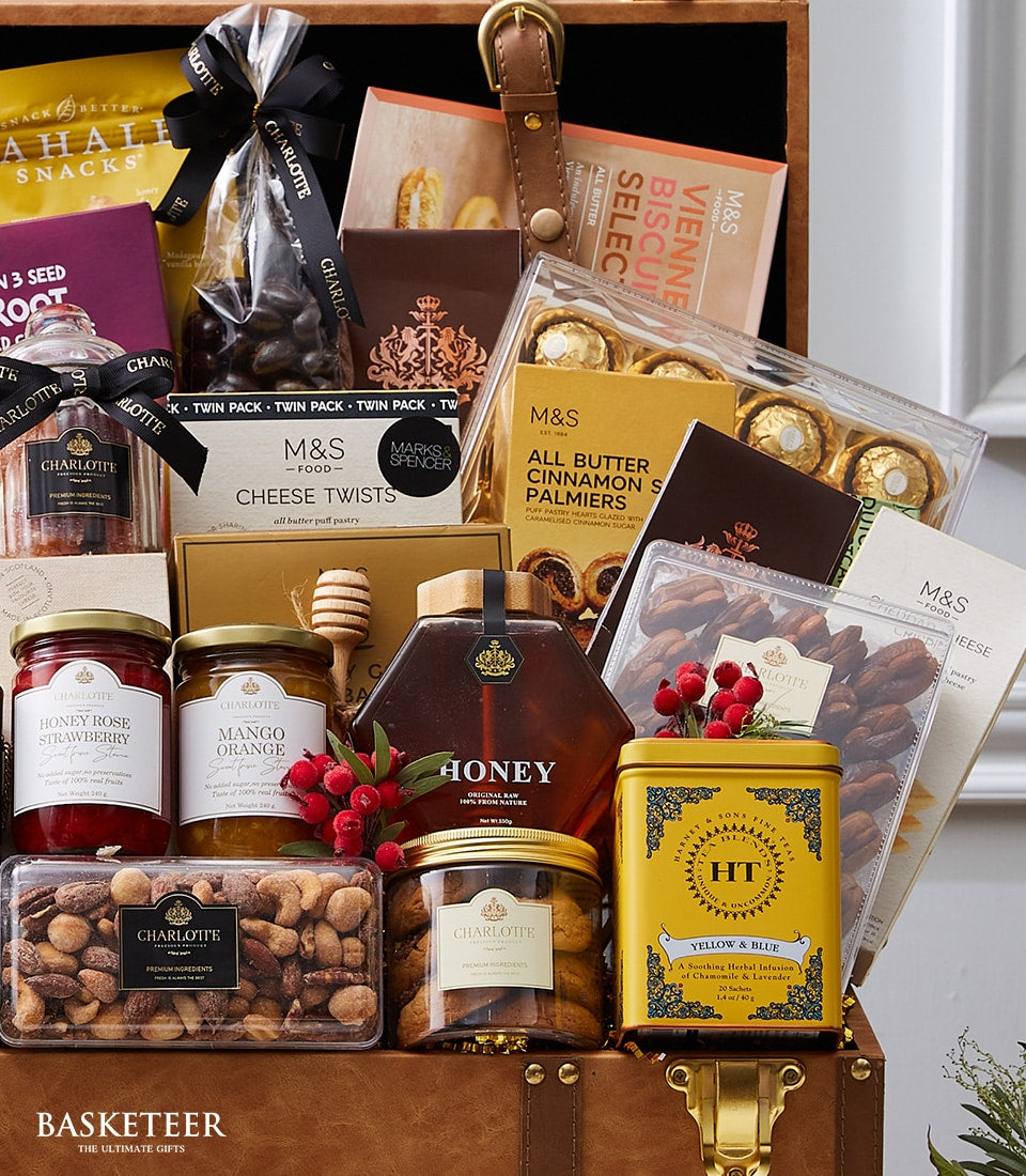 Exotic gourmet hamper with chocolates, jams, nuts, and biscuits in leather trunk with brass clasps