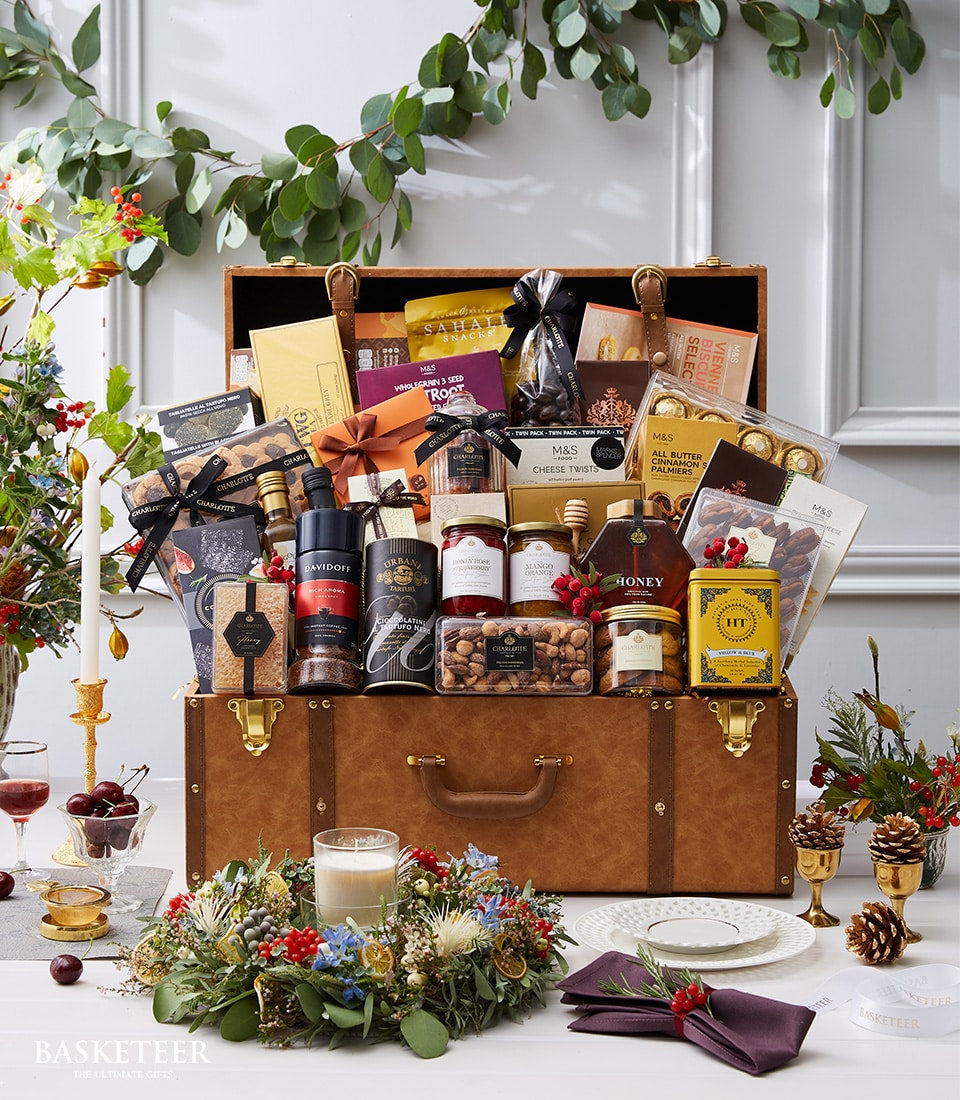 Luxury brown leather trunk hamper filled with gourmet chocolates, honey, nuts, preserves, and festive gifts