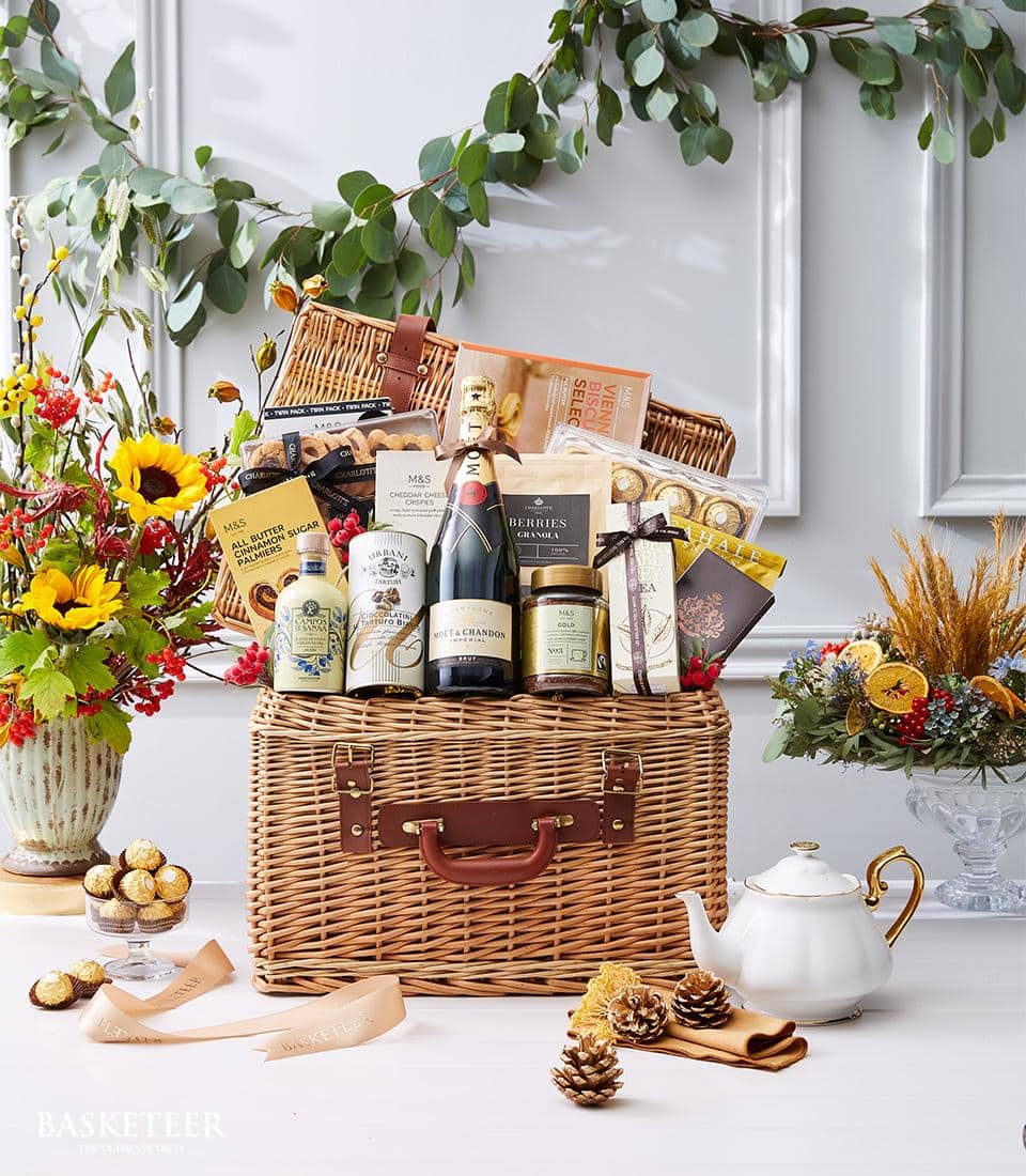 Luxury wicker hamper with Moët champagne, gourmet biscuits, and artisan treats in cream and gold packaging