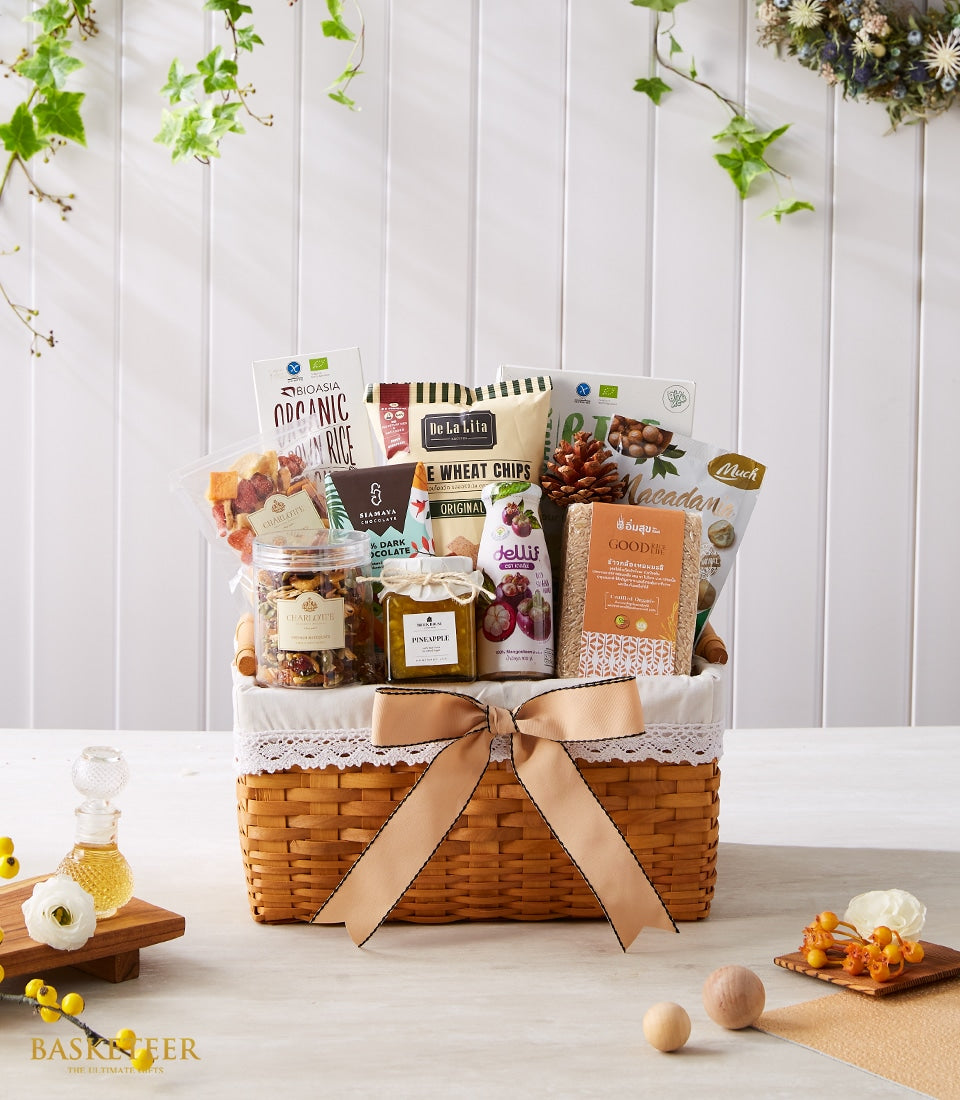 Woven gift basket filled with organic brown rice, whole wheat chips, dark chocolate, macadamia nuts, pineapple jam, and