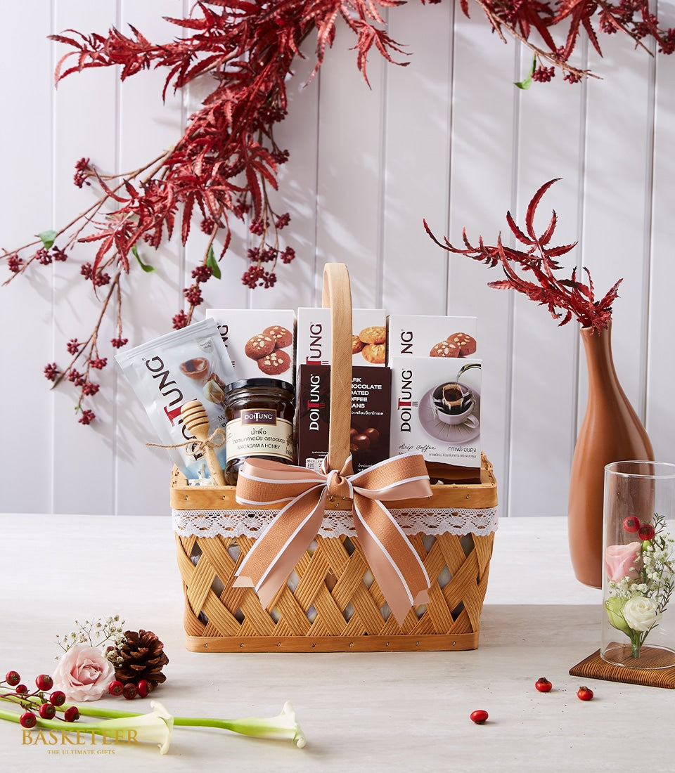 Taste of Doi Tung gift basket with honey, white boxes, and fresh pink and white roses in cream and brown tones