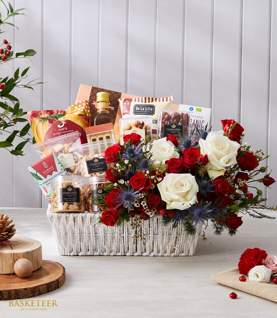 Premium Thai gourmet gift basket with red and white roses, blue thistles, and artisan snacks