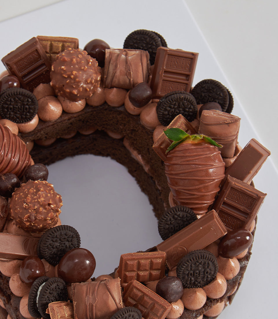 Chocolate Overload Letter Cake with chocolate bars, truffles, cookies, and strawberry for birthday celebrations
