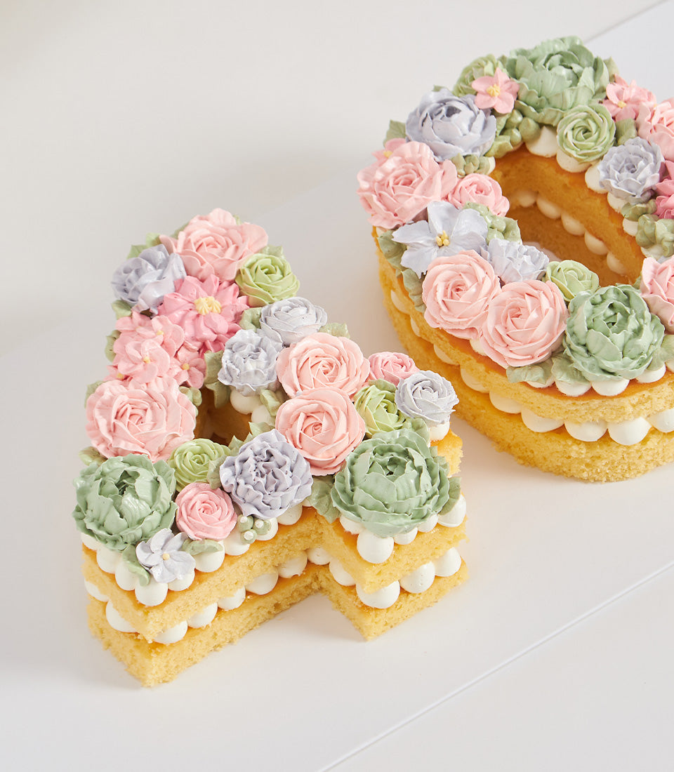 Pastel floral number cakes "4" and "0" with layered sponge, white frosting, and buttercream flowers in pink, green, and