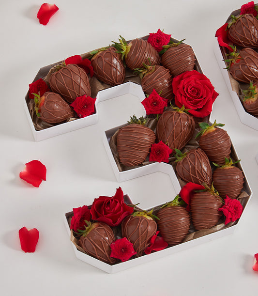 Chocolate-covered strawberries with red roses arranged in number 3 gift box for birthdays