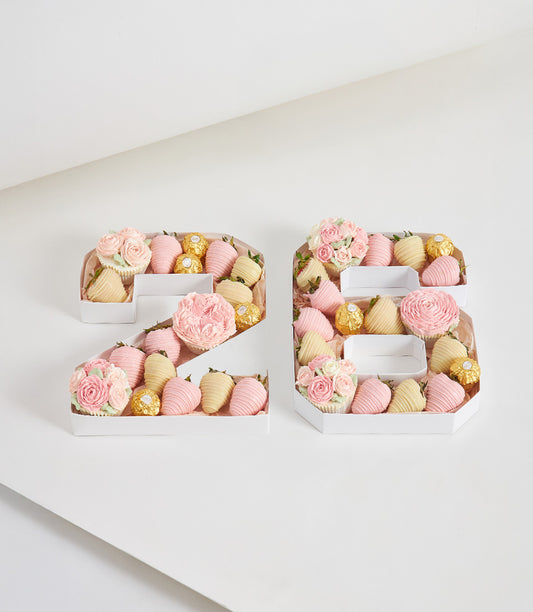 Romantic number boxes filled with chocolate-covered strawberries, Ferrero Rocher, and floral cupcakes for birthday