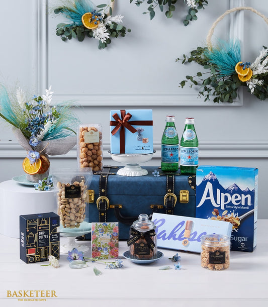 Premium gourmet hamper with blue leather trunk, sparkling water, artisan coffee, nuts, and muesli gift set