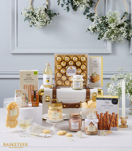 Deluxe white vintage trunk hamper with Ferrero Rocher chocolates, gourmet snacks, and artisan treats on elegant display