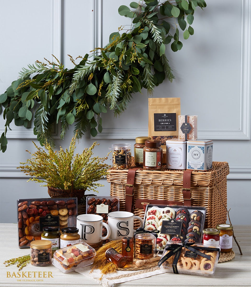 Large wicker gourmet hamper with leather straps filled with premium nuts, teas, chocolates, jams, and honey