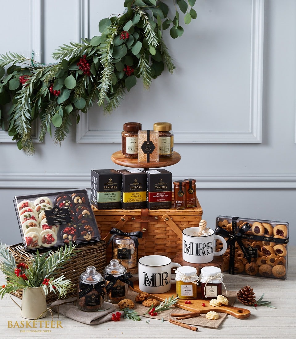 Luxury wicker hamper with imported teas, artisan chocolates, preserves, gourmet cookies, and festive berries
