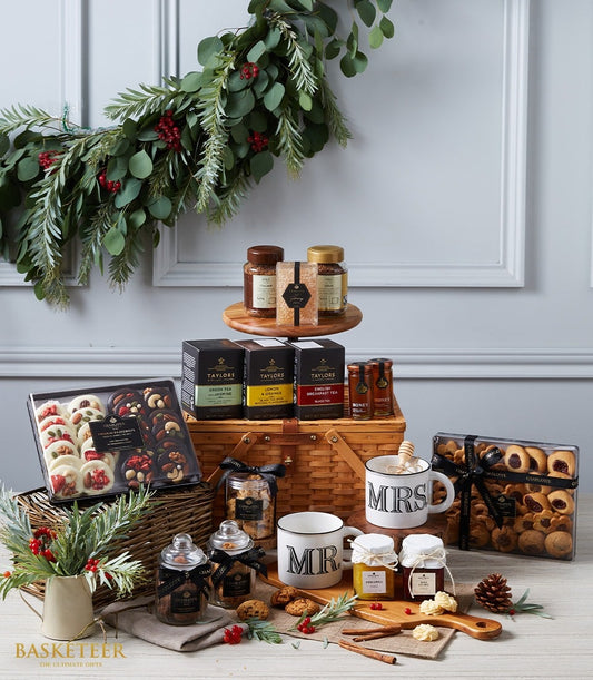 Luxury wicker hamper with imported teas, artisan chocolates, preserves, gourmet cookies, and festive berries