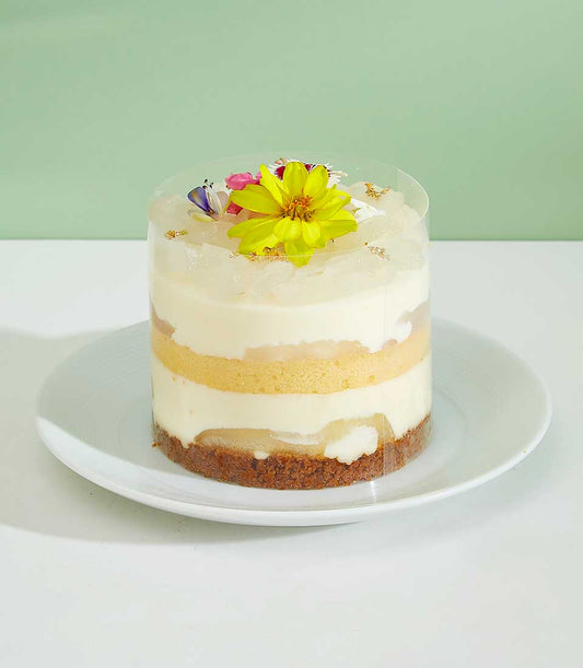 Mini Luktan Layer Cake with tropical fruit, cream mousse, and edible flowers in clear cylindrical container