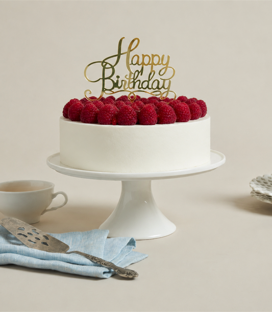 Charlotte Bakery's artisan round birthday cake with smooth white buttercream, topped with luscious