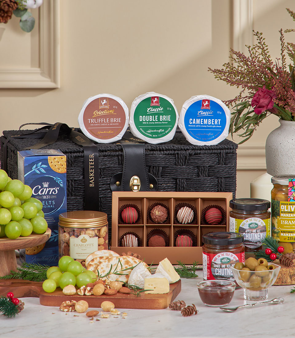 Luxury black woven basket with Truffle Brie, Double Brie, and Camembert cheeses, crackers, nuts, grapes, and gourmet spre