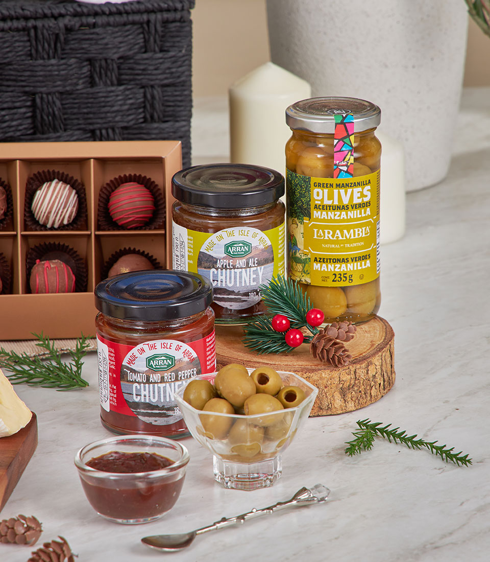 Gourmet gift basket with brie, artisan chutneys, olives, chocolate truffles and festive holiday styling