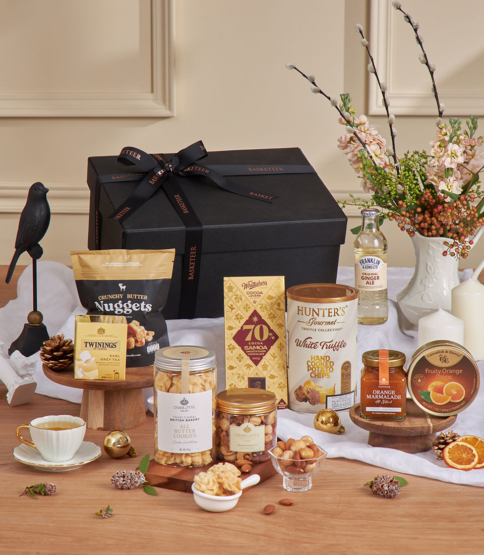 Luxury gift basket with Twinings Earl Grey tea, gourmet chocolates, cookies, and artisan treats in black presentation box