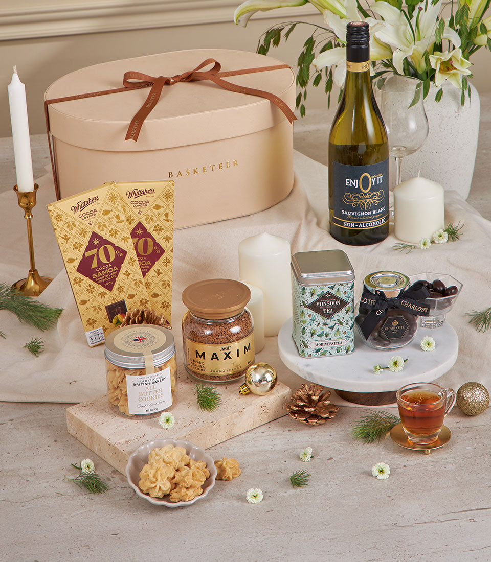 Beige luxury gift basket with gourmet chocolates, premium coffee, artisan cookies, and festive white flowers for New Year