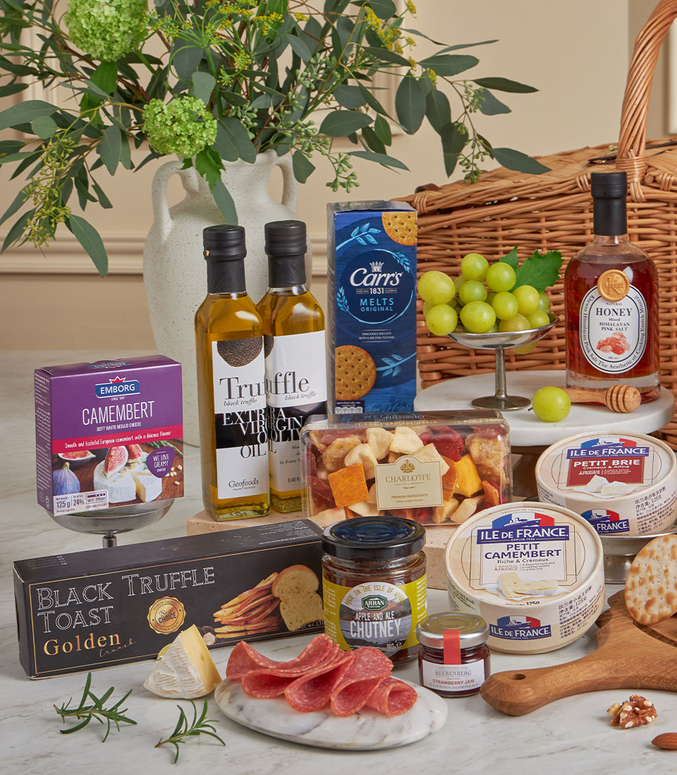 Premium gourmet hamper with truffle oil, artisan cheeses, charcuterie, and fresh fruit on marble board
