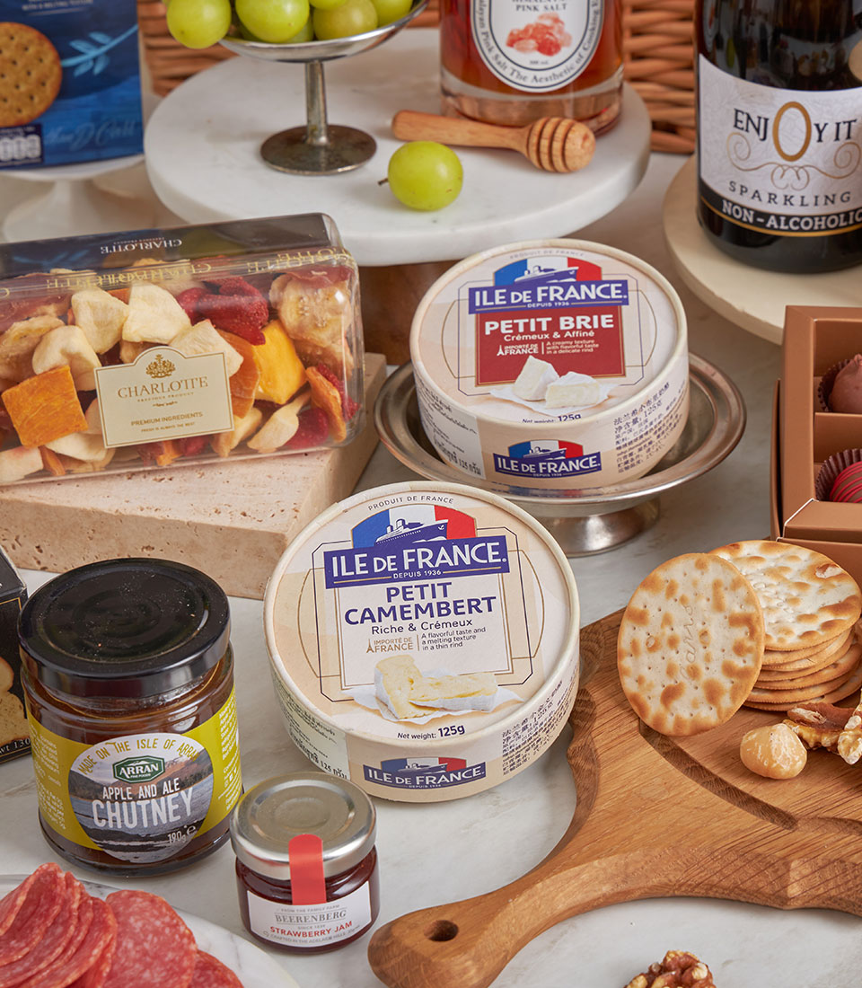 Premium gourmet hamper with French cheeses, cured meats, artisan jams, crackers, nuts, and sparkling beverages