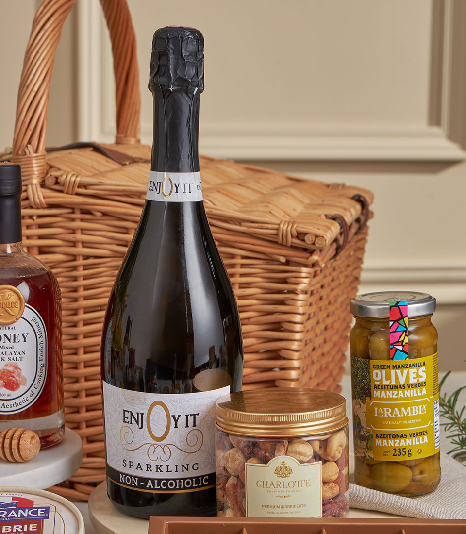 Ultimate gourmet gift hamper with sparkling beverage, honey, premium nuts, and olives in wicker basket