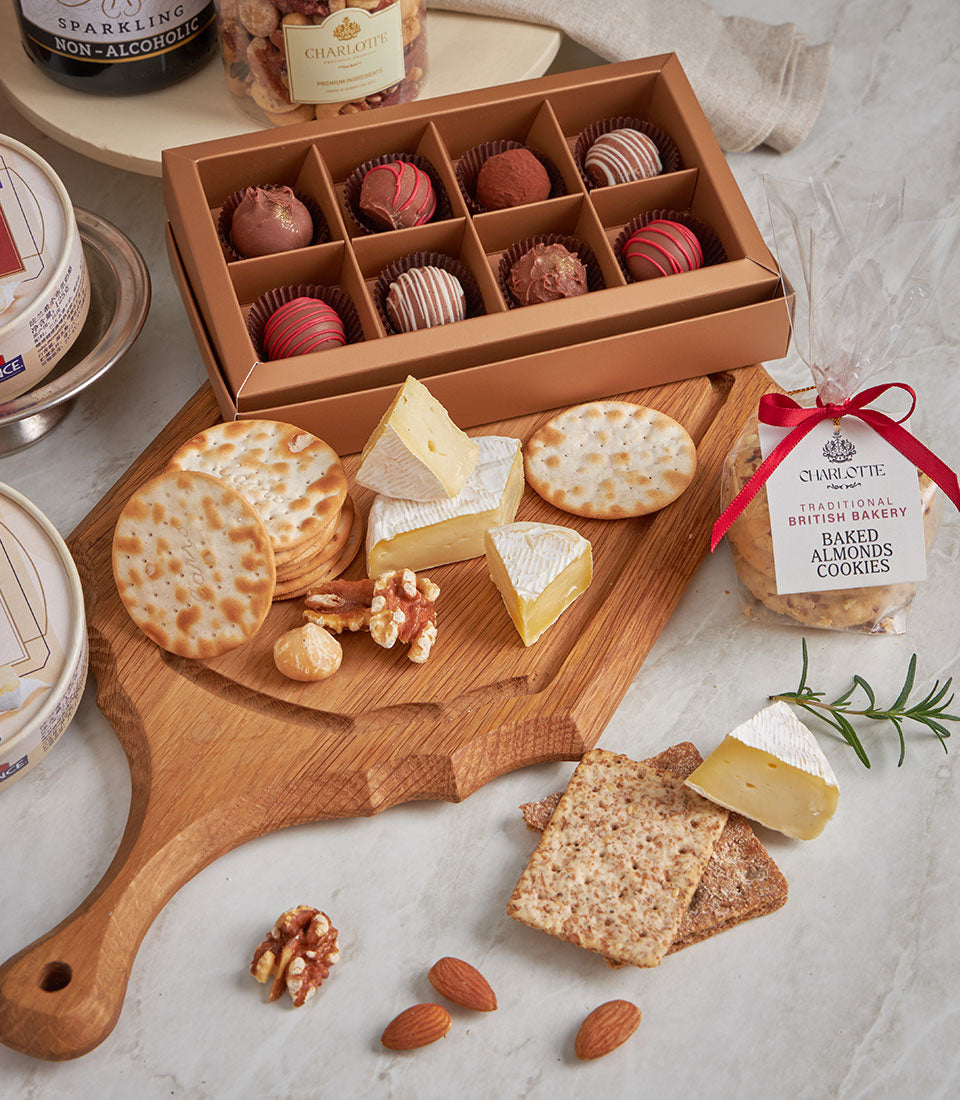 Premium gourmet hamper with artisan cheeses, chocolate truffles, nuts, and British baked almonds on marble