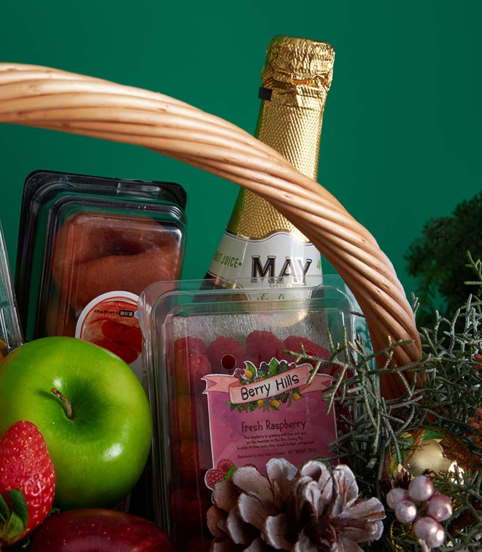 Premium Christmas fruit basket with wicker handle, gourmet treats, fresh raspberries, and festive pine décor