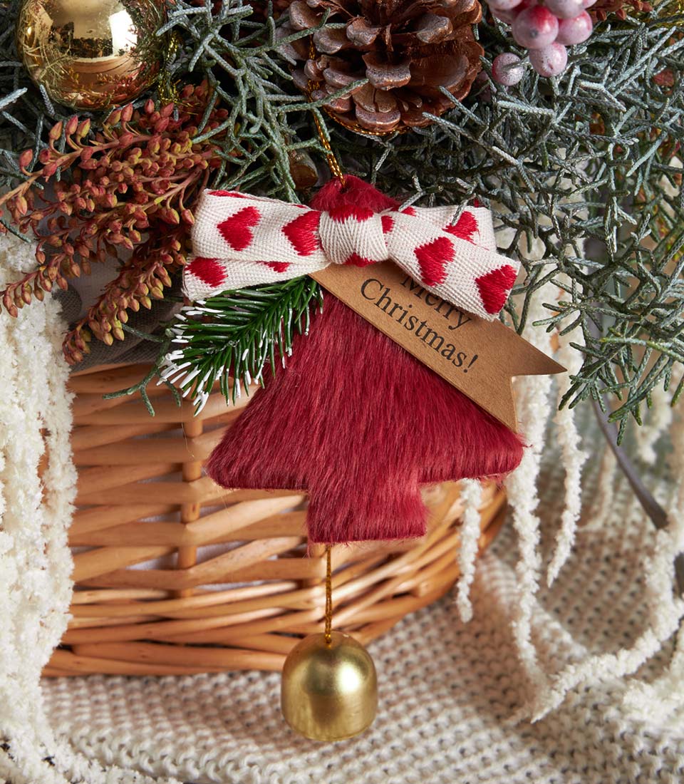 Festive Christmas fruit basket with red tree ornament, golden bell, and holiday foliage in wicker