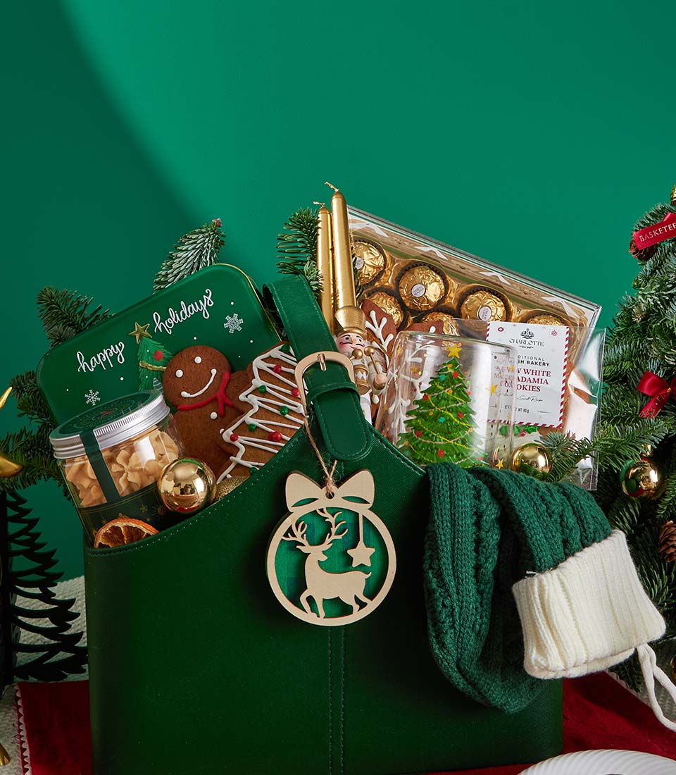 Premium Christmas gift basket with green tote, gingerbread cookies, chocolates, and festive decorations