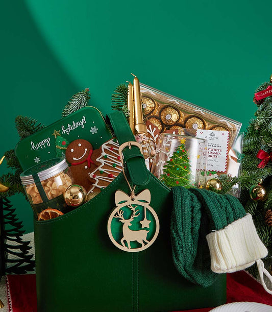 Premium Christmas gift basket with green tote, gingerbread cookies, chocolates, and festive decorations