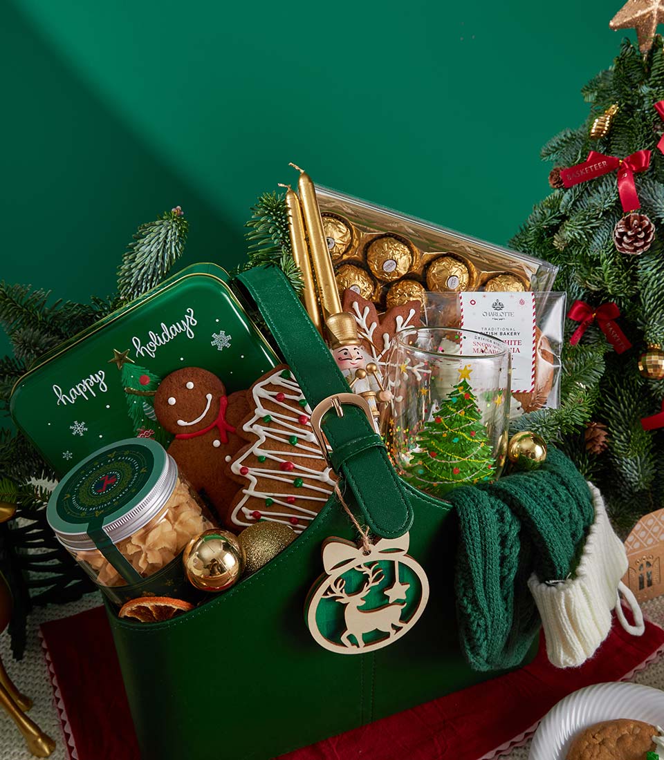 Deluxe Christmas cookies and chocolate gift set in dark green structured bag with gold accents, filled with gingerbread