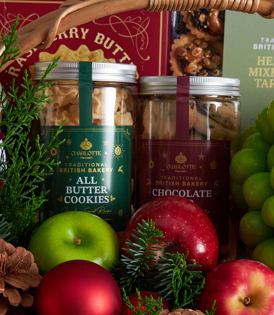 Christmas gift basket with Charlotte bakery cookies, fresh fruit, and festive greenery