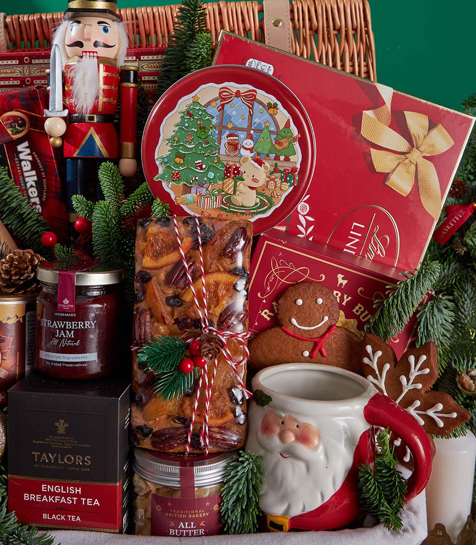Festive Christmas gift basket with gourmet treats, tea, fruitcake, nutcracker, and holiday mug