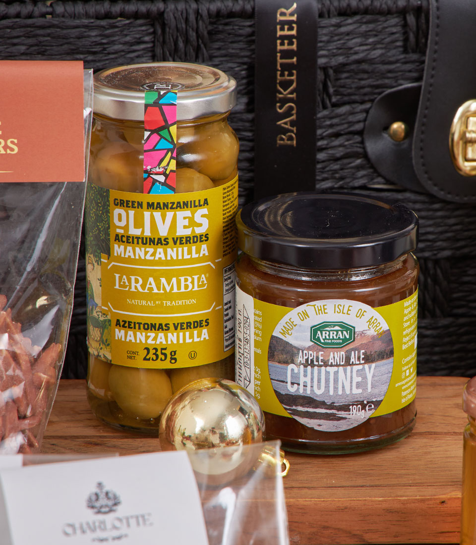 Artisan cheese and gourmet snack hamper with Spanish olives, chutney, and golden accents