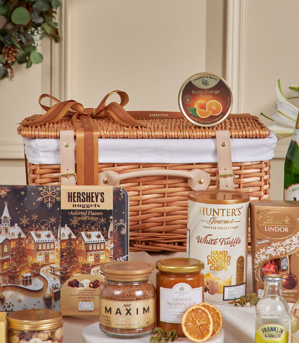 Elegant wicker hamper filled with gourmet chocolates, truffle chips, marmalade, and premium beverages for New Year